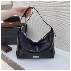 Detail of black leather hobo bag featuring silver metal zipper and smooth polished finish