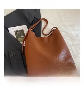 Detailed macro view of caramel brown lychee grain faux leather on a large tote bag