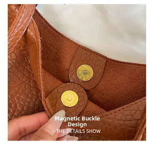 Close-up of brown pebbled leather bag featuring a gold magnetic snap closure