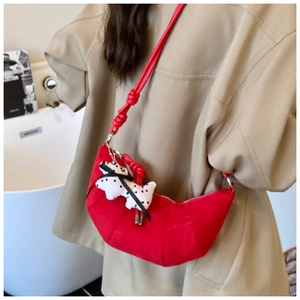 Red crescent shoulder bag with pleated texture and cute dalmatian plush keychain accessory