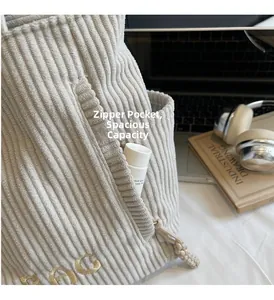 Détail du sac cabas en velours côtelé avec poche zippée cachée et broderie dorée élégante