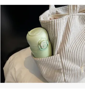 Détail de la poche latérale du sac fourre-tout en velours avec une bouteille