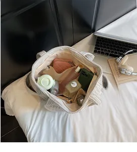 Vue de dessus de l'intérieur spacieux du fourre-tout en velours côtelé crème avec accessoires