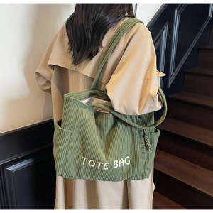 Détail du grand sac cabas en velours côtelé vert avec broderie blanche et texture épaisse