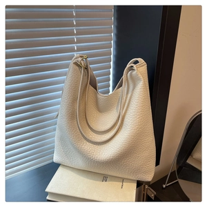 Detail of white lychee texture shoulder bag with adjustable golden metal buckle
