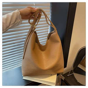 Close-up of brown textured leather hobo bag with adjustable strap and gold hardware