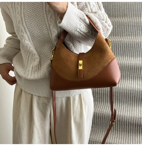 Detail view of brown hobo bag showing color-block suede leather and gold piston lock