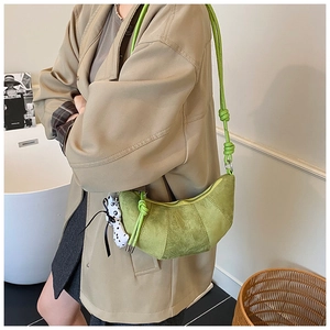 Dettaglio borsa a mezzaluna verde lime smerigliata con ciondolo animale a pois carino