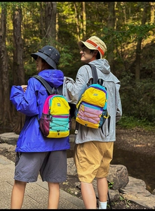Detail of color-block hiking backpacks featuring elastic drawstrings and mesh side pockets