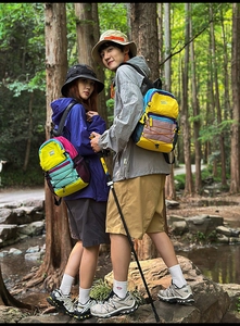 Detail view of colorful hiking backpacks with front bungee system in outdoor forest scenery