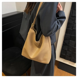 Detail of light brown lychee grain leather hobo bag with adjustable gold metal buckle