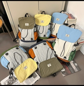Detail view of multi-color nylon backpacks with drawstring closure and buckle flaps