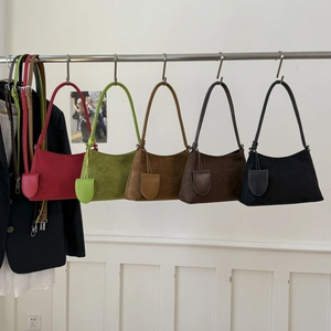 Group display of five colorful frosted suede bucket bags hanging on a rack