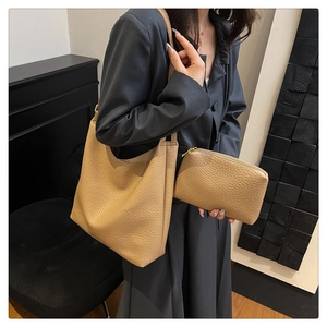 Detail view of large apricot pebble leather tote bag set with matching small zipper pouch