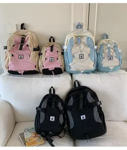 Three color variants of lightweight nylon backpacks in two sizes on a white sofa