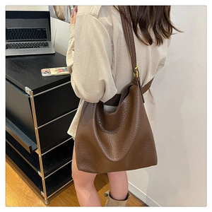 Detail of deep brown pebble leather hobo bag showing texture and adjustable strap