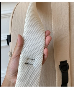 Detail of breathable honeycomb mesh shoulder straps on a beige nylon outdoor backpack
