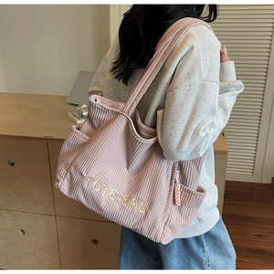 Sac fourre-tout rose en velours côtelé avec détails de broderie jaune et texture fine