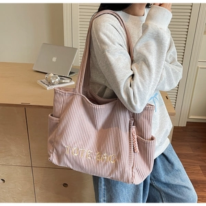 Détail du sac fourre-tout en velours côtelé rose avec poches et broderie lettrage tote bag