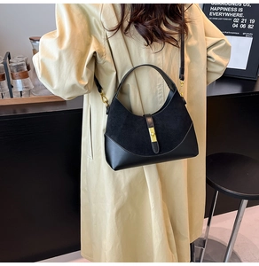 Detail showing mixed texture of suede and leather on black crescent bag with gold buckle