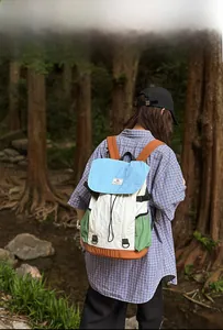 Outdoor lifestyle shot of a multi-color casual backpack with drawstring design and flaps