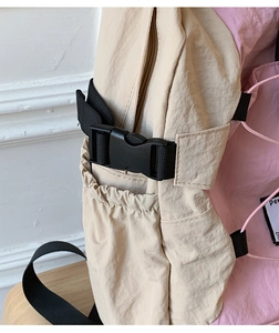 Detail of pink and beige outdoor backpack with plastic side buckle and mesh pocket
