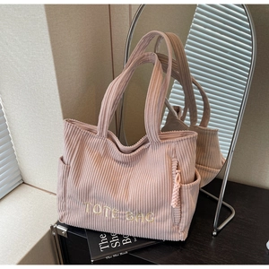 Détail du cabas en velours côtelé rose avec poches latérales et broderie TOTE BAG