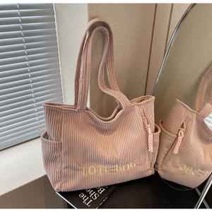 Détail du sac cabas en velours côtelé rose avec broderie et poche latérale en intérieur