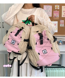 Pink and beige outdoor backpack detail featuring bungee cords and a secure buckle closure