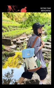Detail of multi-color nylon backpack featuring drawstring closure and top flap design