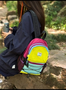 Outdoor scene of a colorful hiking backpack with padded straps and water-resistant nylon