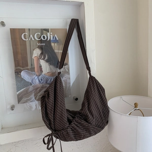 Detail of deep coffee checkered canvas hobo bag with adjustable drawstring and wide strap
