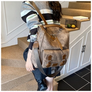 Close-up of vintage brown leather backpack with adjustable straps in a cozy indoor setting