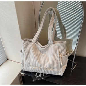 Détail du sac fourre-tout en velours côtelé crème avec broderie et zip tressé