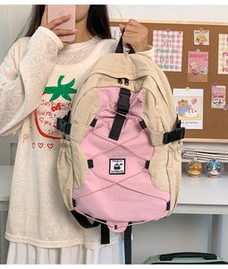 Detail of color-block nylon backpack featuring drawstring cords and buckle closure