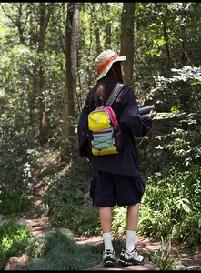 Close-up of lightweight hiking backpack featuring colorful patchwork and bungee cord details