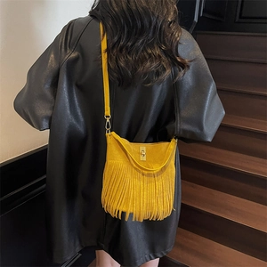 Detail of yellow fringed crossbody bag with suede texture and metal twist lock
