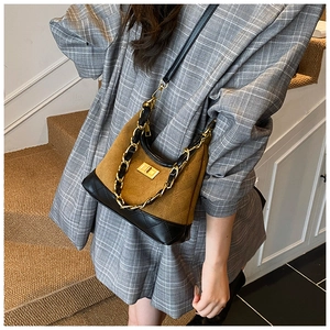 Close-up of retro rhombus quilted bag with suede texture and gold chain detail
