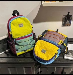 Detail view of colorful nylon backpack with contrast stitching and elastic drawcord system