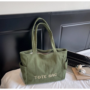 Détail du sac cabas en velours côtelé vert foncé avec broderie et poches latérales