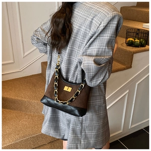 Close-up of vintage quilted leather shoulder bag with golden chain strap on a model
