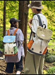 Detail of multi-color nylon outdoor backpack featuring flap closure and drawstring design