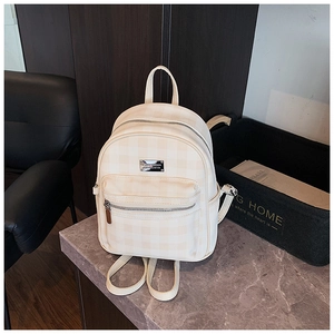 Détail du mini sac à dos à carreaux blanc crème en cuir synthétique avec logo en métal