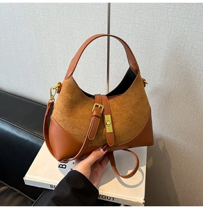 Close-up of contrast leather shoulder bag with gold hardware and suede texture
