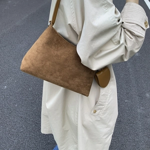Brown suede hobo bag with mini round pouch shown styled with a beige trench coat