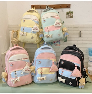 Detail view of colorful student backpacks featuring cute charms and capybara lettering