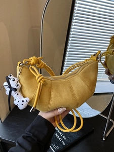 Borsa a mezzaluna in camoscio giallo opaco con tracolla a nodo e ciondolo dalmata