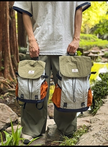 Detail of olive green and beige color-block nylon backpacks in large and small sizes