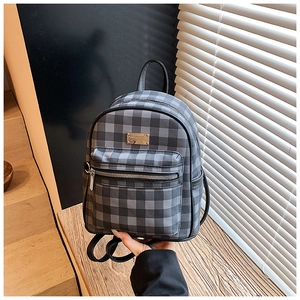 Détail du mini sac à dos vintage à damier avec poche zippée et logo métallique de marque