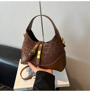 Detail of leopard print suede texture and gold square turn-lock on the hobo handbag